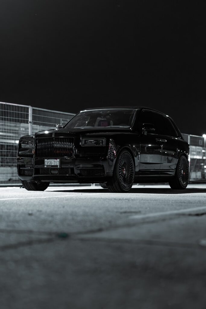 a black car parked in a parking lot at night